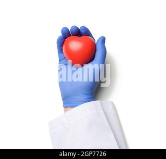 main de médecin mâle dans des gants en latex bleu et un manteau blanc tenant un coeur rouge, concept de don, fond blanc Banque D'Images