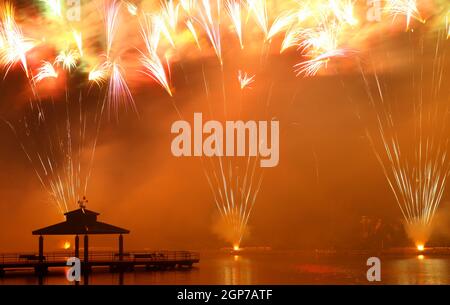 Feux d'artifice au parc Delco. Jetée de pêche et pavillon en avant-plan de feux d'artifice au sol. Delco Park, Kettering, Dayton, Ohio, États-Unis. Banque D'Images