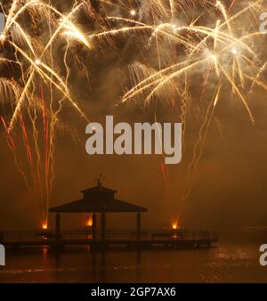 Feux d'artifice au parc Delco. Jetée de pêche et pavillon en avant-plan de feux d'artifice au sol. Delco Park, Kettering, Dayton, Ohio, États-Unis. Banque D'Images