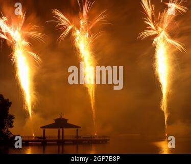 Feux d'artifice au parc Delco. Jetée de pêche et pavillon en avant-plan de feux d'artifice au sol. Delco Park, Kettering, Dayton, Ohio, États-Unis. Banque D'Images