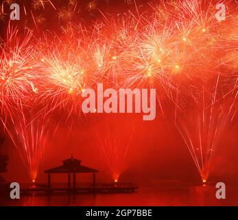 Feux d'artifice au parc Delco. Jetée de pêche et pavillon en avant-plan de feux d'artifice au sol. Delco Park, Kettering, Dayton, Ohio, États-Unis. Banque D'Images