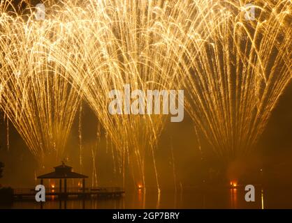 Feux d'artifice au parc Delco. Jetée de pêche et pavillon en avant-plan de feux d'artifice au sol. Delco Park, Kettering, Dayton, Ohio, États-Unis. Banque D'Images