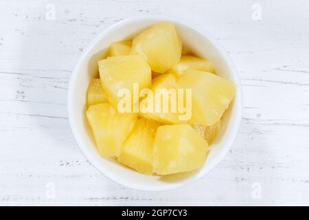L'ananas coupe des fruits du bol sur une planche en bois Banque D'Images