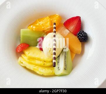 Salade de fruits frais avec crème glacée et gaufres au chocolat. Banque D'Images