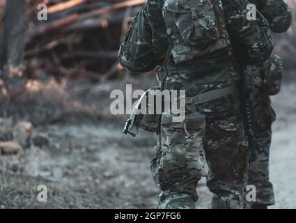 Les joueurs de jeux militaires Airsoft des uniformes de camouflage avec Armed Assault Rifle. Banque D'Images