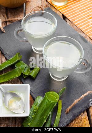 Boire de l'aloe vera et miel. Tasses en verre sur un plateau d'ardoise Banque D'Images