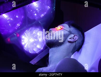 Jeune homme mince au solarium en instituts de beauté. Banque D'Images