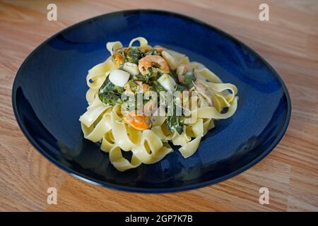 Fettuccine avec sauce à la crème au fromage aux épinards et fruits de mer une plaque Banque D'Images