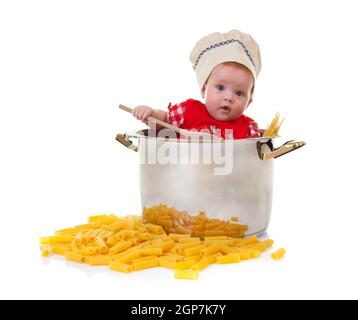 Mignon bébé chef dans un énorme pot avec des pâtes sur fond blanc. Banque D'Images