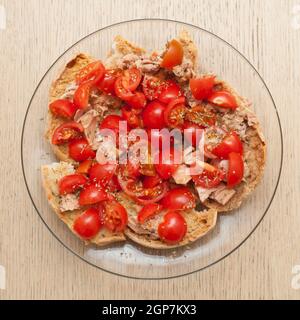 Pain séché appelé freselle avec du thon et des tomates sur la table en bois Banque D'Images