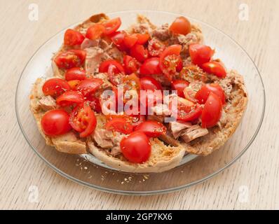 Pain séché appelé freselle avec du thon et des tomates sur la table en bois Banque D'Images