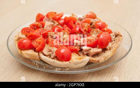 Pain séché appelé freselle avec du thon et des tomates sur la table en bois Banque D'Images