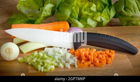 Couteau en céramique avec planche à découper en bois sur soffritto Banque D'Images