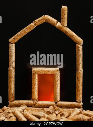Maison miniature faite avec les granulés de bois. Chauffage concept avec chambre de combustion à l'arrière-plan. Banque D'Images