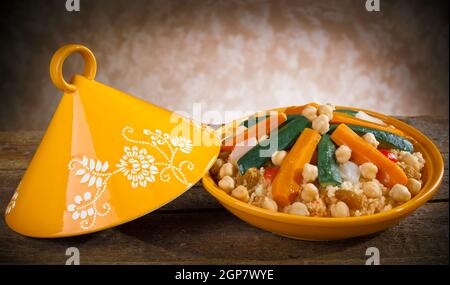 Tajine de légumes à couscous sur table en bois. Banque D'Images