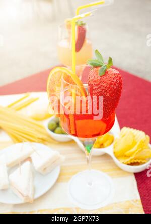Verre à cocktail avec fruits à la table à l'extérieur. Banque D'Images
