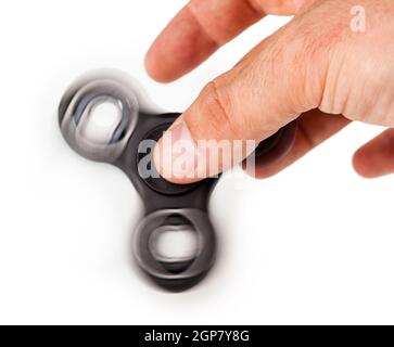 Avec un Noir Palying Fidget Spinner isolé sur fond blanc Banque D'Images