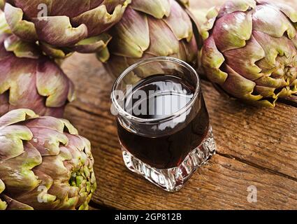 Boisson alcoolisée à l'extrait d'artichaut sur table en bois. Banque D'Images