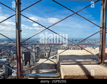 Vue de Manhattan depuis le dernier étage de l'Empire State Building de derrière le grillage de protection, New York City Banque D'Images