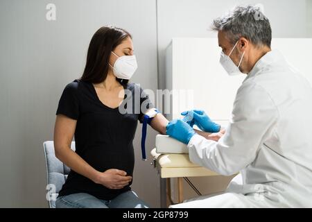 Femme enceinte prise de sang par le docteur en laboratoire dans le visage Masque Banque D'Images
