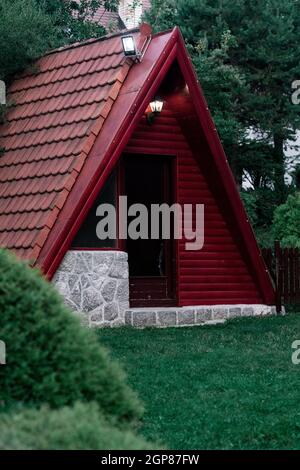 Maison triangulaire dans la nature remplie de bois et de buissons Banque D'Images