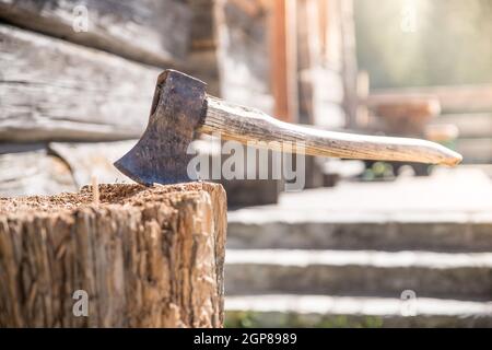 Vieille ax attaché à un tronc d'arbre, alpine hut Banque D'Images