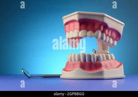 Une exposition de dents dentaires et un miroir professionnel de la bouche sur bleu pour les dentistes. Banque D'Images