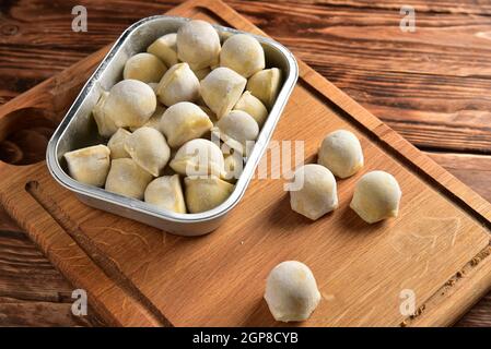Raviolis faits maison congelés sur table en bois. Banque D'Images