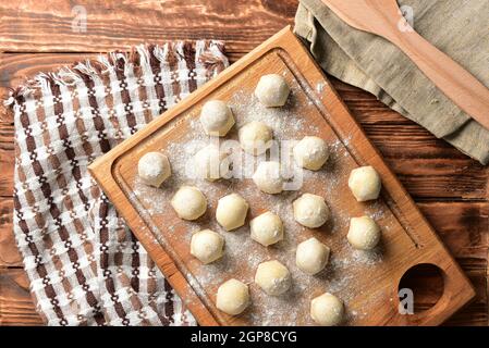 Raviolis faits maison congelés sur table en bois, cuisson des boulettes de pelmeni semi-finies. Banque D'Images