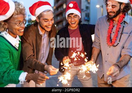 Groupe de jeunes divers célébrant noël ou le nouvel an dans la rue de la ville Banque D'Images