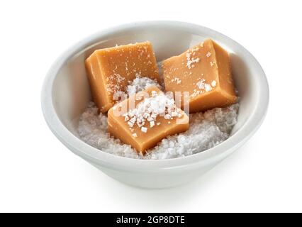 Morceaux de caramel crémeux fudge dans un bol de gros sel sur un fond blanc dans une vue en grand angle Banque D'Images