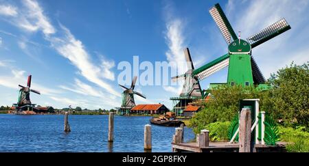 ZAANSE SCHANS, PAYS-BAS - VERS AOÛT 2020 : moulin à vent hollandais dans la campagne verte près d'Amsterdam, avec ciel bleu et eau de rivière. Banque D'Images