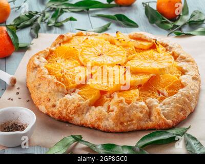 Vue rapprochée de la caraway et de la tarte orange sur le papier de fond sur fond de ciment noir. Recette pour la saison d'hiver et les idées de noël - tarte avec carvi p Banque D'Images