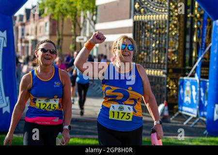 Warrington Running Festival 2021 - main dans l'air comme deux femmes franchissent la ligne d'arrivée Banque D'Images