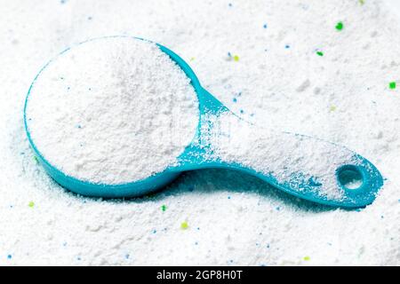 Tasse ou cuillère bleue de détergent en poudre blanc pour le lavage des vêtements Banque D'Images