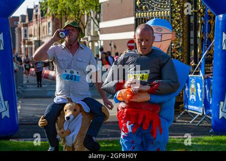 Warrington Running Festival 2021 - deux gars en robe de fantaisie franchissent la ligne d'arrivée Banque D'Images