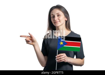 Bonne jeune femme blanche, drapeau sud-soudanais, pointe vers la gauche isolée sur fond blanc. Banque D'Images