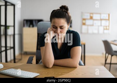 Femme stressée et ennuyée avec douleur au bureau Banque D'Images