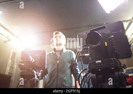 Un caméraman masculin utilise une caméra de cinéma dans un téléviseur studio d'enregistrement Banque D'Images