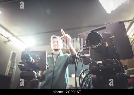 Un caméraman masculin utilise une caméra de cinéma dans un téléviseur studio d'enregistrement Banque D'Images