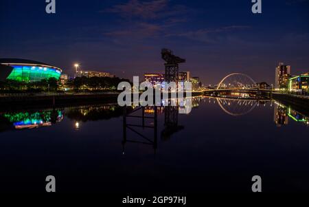 Glasgow, Écosse, Royaume-Uni. 28 septembre 2021 EN PHOTO : vue nocturne du site de la COP26 montrant la rivière Clyde et la SEC Hydro Arena (éclairée en vert) sur la gauche avec la grue Finnieston au milieu et l'Arc de Clyde (connu localement sous le nom de pont Squinty) sur la droite. Crédit : Colin Fisher/Alay Live News. Banque D'Images