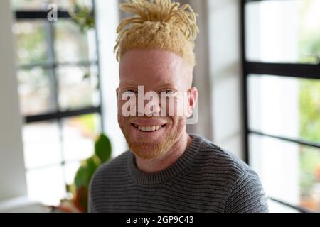 Portrait d'un homme afro-américain heureux avec des dreadlocks dans le salon Banque D'Images