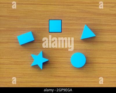Blocs de construction bleus assortis sur une table en bois. Image conceptuelle du jouet éducatif et test psychologique. Banque D'Images
