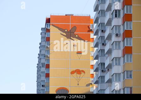 Une maison à plusieurs étages avec un mur peint. La figure illustrant l'atterrissage des parachutistes d'un avion. Banque D'Images