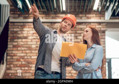 Homme expliquant le plan de construction à la femme Banque D'Images