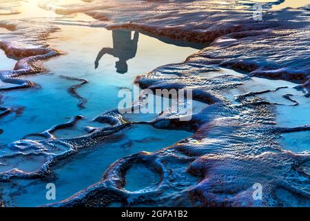 Reflet d'un touriste dans les piscines de Travertine dans un léger coucher de soleil. Beauté de la nature. Célèbre attraction touristique. Pamukkale. Turquie. Banque D'Images