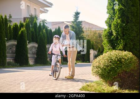 Papa enseignant à sa fille de faire du vélo Banque D'Images