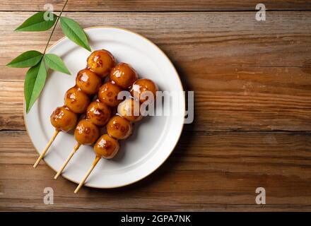 Mitarashi-dango (boulettes de riz) placé sur un fond d'arbres avec un espace de copie. Vue de dessus Banque D'Images