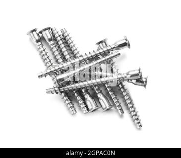 Nombreuses vis à tête creuse métalliques sur fond blanc Banque D'Images