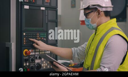 Ouvrier d'usine asiatique travaillant la programmation automatique CNC de commande de fraisage centre de l'industrie des machines pour la fabrication d'ateliers d'outillage Banque D'Images